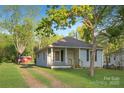 Traditional home with a covered porch, green lawn, and a long driveway on a sunny day at 872 Wellman St, Gastonia, NC 28054