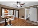 Bright living room featuring hardwood floors, a ceiling fan, and stylish barn doors opening to adjacent rooms at 872 Wellman St, Gastonia, NC 28054