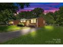Beautiful brick home with manicured lawn at dusk, featuring inviting exterior lighting and a serene ambiance at 1053 Stoneybrook Ln, Rock Hill, SC 29730