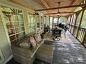 Spacious covered deck with comfortable seating, dining area, and grill at 127 Hummingbird Cir, New London, NC 28127