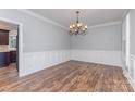 Elegant dining room with hardwood floors, wainscoting, crown molding, and a decorative chandelier at 1468 Woodhurst Dr, Rock Hill, SC 29732