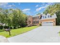 Attractive brick home with a well-maintained lawn, mature trees, and a long driveway leading to a two-car garage at 1468 Woodhurst Dr, Rock Hill, SC 29732