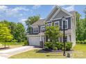 Well-manicured front yard of home, with lovely shrubbery, mature trees, and convenient two-car garage at 1552 Trentwood Dr, Fort Mill, SC 29715