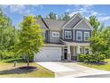 Beautiful home with a two-car garage, manicured lawn, and a welcoming front porch framed by stone pillars at 1552 Trentwood Dr, Fort Mill, SC 29715