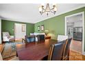 Cozy dining room featuring hardwood floors, a chandelier, and green walls at 2100 Stonewood Dr, Charlotte, NC 28210