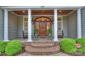 Inviting front porch with stately columns, a wood door, and elegant outdoor seating, creating a welcoming entrance at 299 Barber Loop, Mooresville, NC 28117