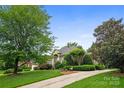 Beautiful brick home showcasing its landscaped front yard, winding driveway, and lush mature trees at 3420 Maryhurst Ln, Charlotte, NC 28226