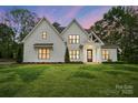 Two-story white farmhouse-style home with modern black trim, a covered porch and manicured lawn at 6712 Cove Ln, Sherrills Ford, NC 28673