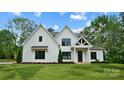 Charming two-story white farmhouse with black trim, a gabled roof, and a well-maintained lawn at 6712 Cove Ln, Sherrills Ford, NC 28673