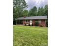 Charming one-story brick home featuring a carport, manicured lawn, and mature trees at 755 Victory Grove Church Rd, Lincolnton, NC 28092