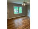 Bright living room featuring hardwood floors, ceiling fan, and view of the front yard through a large window at 755 Victory Grove Church Rd, Lincolnton, NC 28092