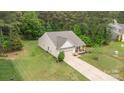 Aerial view of a well-maintained home with a long driveway, lush lawn, and surrounding mature trees on a large lot at 8112 Mossy Rock Rd, Waxhaw, NC 28173