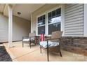 Inviting covered front porch with brick accents and cozy wicker chairs at 8112 Mossy Rock Rd, Waxhaw, NC 28173