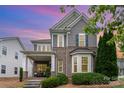 Beautiful two-story home featuring mixed siding, brick accents, lush landscaping and dusk lighting at 9802 Sky Vista Dr, Huntersville, NC 28078