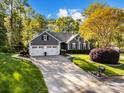 Charming single-Gathering home with a well-manicured lawn, mature trees, and an attached two-car garage at 10009 Lattice Ct, Charlotte, NC 28269