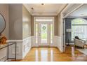 Bright foyer with hardwood floors, wainscoting and a glass front door with transom window at 10012 Royal Colony Dr, Waxhaw, NC 28173