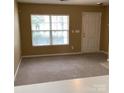 Bright living room featuring neutral walls, carpet flooring, and a large window that brings in natural light at 1012 Kings Mountain Ln, Gastonia, NC 28054