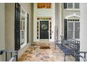 Inviting front porch with stone flooring, bench, and decorated front door at 10319 Remembrance Trl, Huntersville, NC 28078