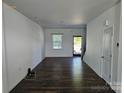 Bright living room with dark wood floors, white walls, and natural light filtering through the window at 106 Calderdale Ln, Charlotte, NC 28262