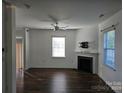 Spacious living room featuring a cozy fireplace, ceiling fan, and large windows for ample natural light at 106 Calderdale Ln, Charlotte, NC 28262