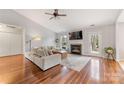 Cozy living room featuring a fireplace, hardwood floors, and plenty of natural light at 12628 Waterfall Pl, Charlotte, NC 28278