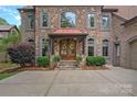Beautiful stone and brick facade with arched windows, copper awning, and a welcoming double-door entrance at 1305 Anniston Pl, Wesley Chapel, NC 28079