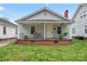 Inviting front porch with swing, seating, and plants on a well-kept lawn at 18 Douglas Nw Ave, Concord, NC 28025
