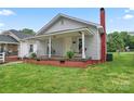 Cozy home featuring a welcoming front porch with a swing and brick foundation at 18 Douglas Nw Ave, Concord, NC 28025
