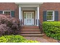 Close-up of the classic brick front entrance of the home with white door and columns at 1949 S Wendover Rd, Charlotte, NC 28211