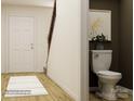 Bright entryway showcasing wood-look floors, a classic white door, and a glimpse into the convenient downstairs powder room at 2112 Columbidae Ln, Gastonia, NC 28052