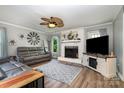 Cozy living room featuring a stylish fireplace, a ceiling fan, and comfortable leather seating at 2278 Jon Chris Dr, Harrisburg, NC 28075