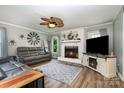 Cozy living room featuring a stylish fireplace, a ceiling fan, and comfortable leather seating at 2278 Jon Chris Dr, Harrisburg, NC 28075