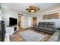 Open-concept living room with modern decor, a ceiling fan and sleek gray sofa for entertaining at 2278 Jon Chris Dr, Harrisburg, NC 28075