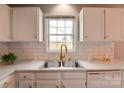 Bright kitchen featuring white cabinets, subway tile backsplash, and stainless steel sink with gooseneck faucet at 301 Walkers Ridge Dr, Shelby, NC 28152