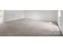 Bright living room featuring neutral carpet and freshly painted white walls at 318 Huffman Rd, Gastonia, NC 28056