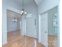 Inviting entryway with hardwood floors, half-moon window over front door and chandelier lighting at 3226 Chatfield Sw Ln, Concord, NC 28027