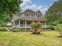 Charming house featuring a spacious front porch, picturesque landscaping, and a well-maintained lawn at 3231 Karen Ln, Monroe, NC 28110