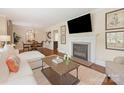 Cozy living room with a fireplace, hardwood floors, and an open view to the dining area at 4346 Walker Rd, Charlotte, NC 28211