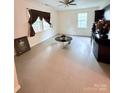Bright living room featuring two windows, a unique table, neutral walls, and a ceiling fan at 522 Pennsylvania Ave, Charlotte, NC 28216