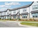 Exterior view of attractive brick and vinyl townhomes with covered entries and landscaped yards at 5712 Runnel Way, Charlotte, NC 28215