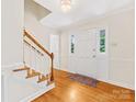 Inviting foyer with hardwood floors, staircase, and a well-lit entryway at 5817 Portburn Rd, Charlotte, NC 28211