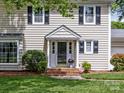 Close up of a home's entrance showcasing a brick pathway and attractive landscaping at 5817 Portburn Rd, Charlotte, NC 28211