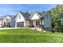 Charming home featuring a black garage door, front porch swing, and manicured lawn at 602 Kames Nw Ct, Conover, NC 28613
