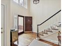 Bright foyer with hardwood floors, staircase, and a decorative front door with sidelight windows at 6645 Gaywind Dr, Charlotte, NC 28226