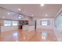 Bright, open-concept living space with hardwood floors, ceiling fan, and view to kitchen at 6813 Rebel Rd, Marshville, NC 28103