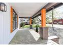 View from the front porch showcasing brick pillars, orange trim, and covered deck at 908 W Airline Ave, Gastonia, NC 28052