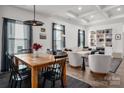 Open-concept dining area with a wooden table and stylish chairs, seamlessly connected to a cozy living space at 1024 Scotch Meadows Loop # 32, Monroe, NC 28110