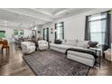 Bright, open living room with tray ceilings, hardwood floors, and a comfortable gray sofa and stylish decor at 1024 Scotch Meadows Loop # 32, Monroe, NC 28110