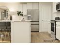 Bright kitchen featuring stainless steel appliances, white cabinetry, an island with seating, and hardwood flooring at 134 Dorian Pl, Troutman, NC 28166