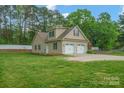 Rear exterior view showing the two-car garage, spacious yard, and manicured landscaping at 2646 N Olivers Cross Rd, Newton, NC 28658